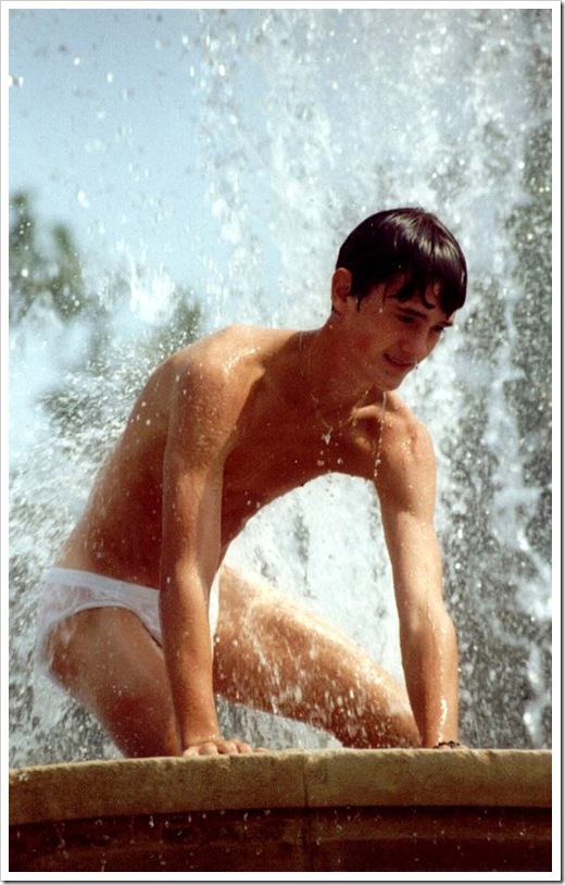 cute boy strips down to his underwear and plays in a fountain