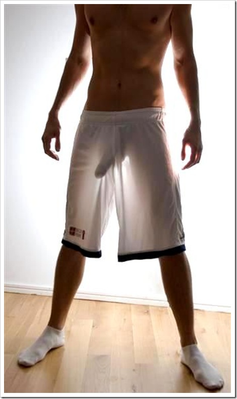 hot boy with big hard cock backlit in gym shorts